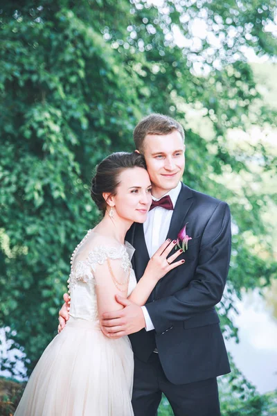 Bruid en bruidegom samen. Bruidspaar. Trouwdag. Mooie bruid en elegante bruidegom lopen na de ceremonie van het huwelijk. Luxe bruids jurk en boeket bloemen. Bruid en bruidegom op de huwelijksdag — Stockfoto