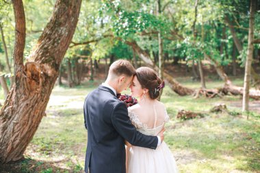 Damat ve gelin birlikte. Düğün çifti. Düğün günü. Güzel gelin ve zarif Damat Düğün töreni sonrası yürüme. Lüks gelinliğin ve buket çiçek. Gelin ve damat, düğün günü