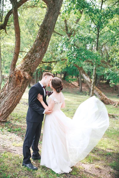 Mariée et fiancée. Un couple. Jour du mariage. Belle mariée et marié élégant marchant après la cérémonie de mariage. Robe de mariée de luxe et bouquet de fleurs. Mariée et marié le jour du mariage — Photo