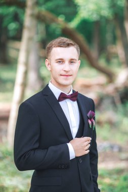  Düğün gününde damat. Muhteşem gülümseyen damat. gülümseyen ve gelin için bekleyen düğün smokin, ve damat. Zarif damat siyah kostüm ve papyon. İlik tutan takım elbiseli damat.