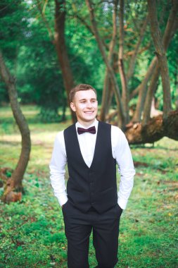  Düğün gününde damat. Muhteşem gülümseyen damat. gülümseyen ve gelin için bekleyen düğün smokin, ve damat. Zarif damat siyah kostüm ve papyon. İlik tutan takım elbiseli damat.