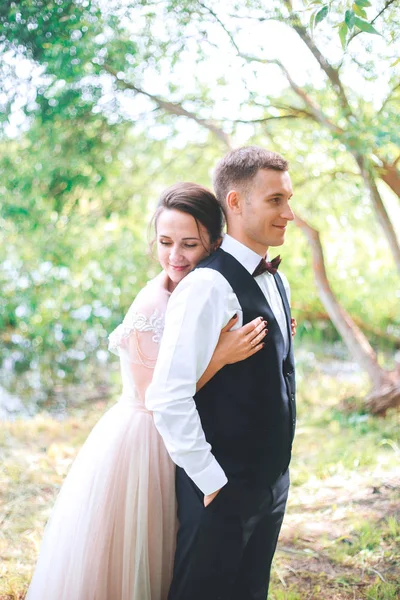 Brudgummen och bruden tillsammans. par som kramas. Bröllopsdag. Vackra brudparet eleganta promenader efter vigseln. Lyxig brudklänning och blombukett. — Stockfoto