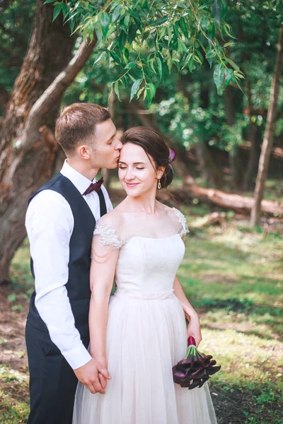 新郎と新婦が一緒に。ハグのカップル。結婚式の日。美しいエレガントな新郎新婦の結婚式の後の歩行します。高級ウエディング ドレスと花の花束. — ストック写真
