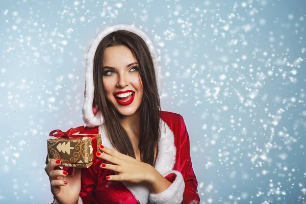 Navidad Santa sombrero mujer retrato celebrar las cajas de regalo de Navidad. Sonriendo chica feliz sobre fondo azul.Retrato de hermosa chica sexy con ropa de Santa Claus — Foto de Stock