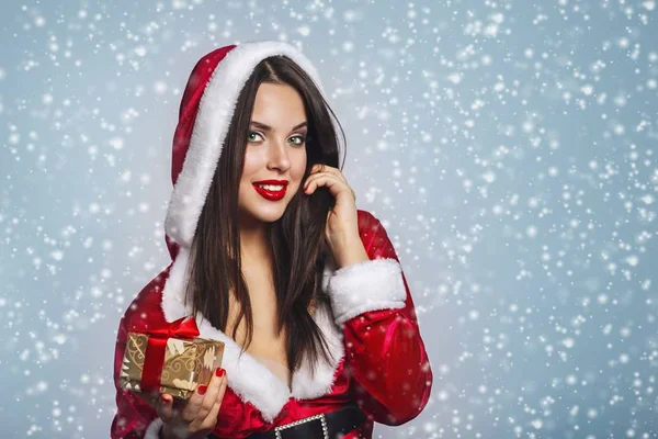 Chapeau de Noël portrait de femme Santa tenir boîtes cadeaux de Noël. Sourire fille heureuse sur fond bleu.Portrait de belle fille sexy portant santa claus vêtements — Photo