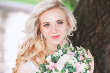 Güzel gelin. Düğün saç ve makyaj. Genç gelin buketi tutan gelinlik