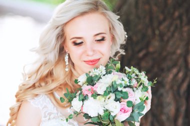 Güzel gelin. Düğün saç ve makyaj. Genç gelin buketi tutan gelinlik