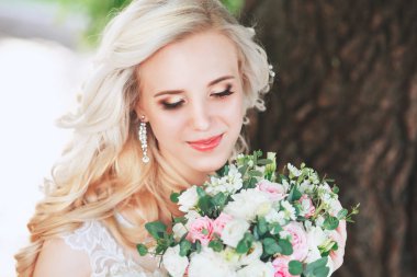 Güzel gelin. Düğün saç ve makyaj. Genç gelin buketi tutan gelinlik