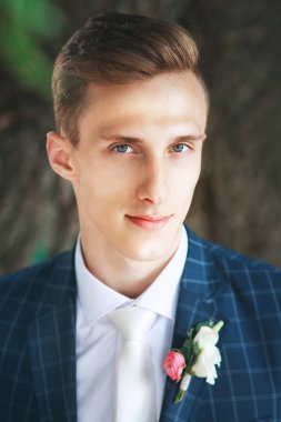 Muhteşem gülümseyen damat. Gülümseyen ve gelin için bekleyen düğün smokin, yakışıklı damat. Zarif adam mavi kostüm ve beyaz kravat.