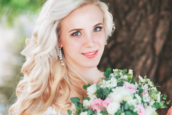 Hermosa novia. Peinado de boda y maquillaje. Novia joven en vestido de novia con ramo de celebración — Foto de Stock