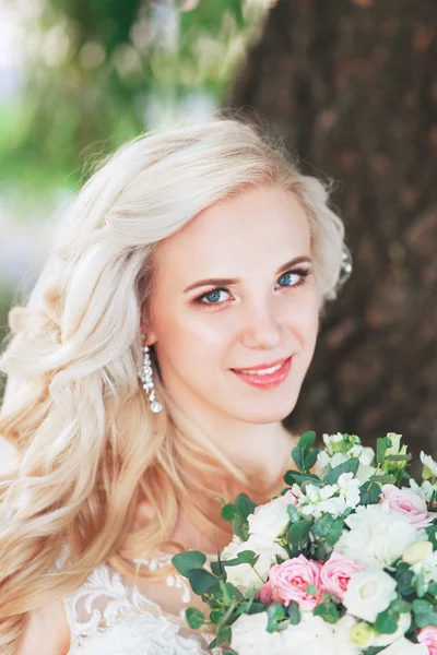 Hermosa novia. Peinado de boda y maquillaje. Novia joven en vestido de novia con ramo de celebración — Foto de Stock