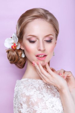 Pembe arka planda moda düğün saç stili olan güzel gelin. Yakından güzel bir gelinin portresi. Düğün için. Stüdyo çekimi.