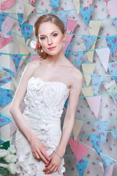 Bride.Young modelka s perfektní pleť a make-upu, květiny ve vlasech. Krásná žena s make-up a účes v ložnici. Šťastná nevěsta čeká ženicha. Svatební den okamžik. — Stock fotografie