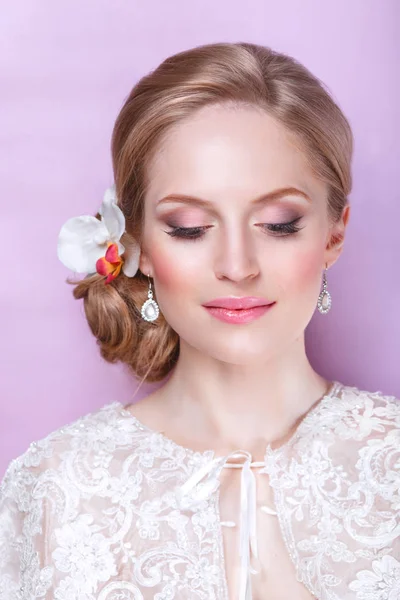 Красива наречена з модною весільною зачіскою на рожевому тлі. Крупним планом портрет молодої розкішної нареченої. Весілля. Студійний знімок . — стокове фото