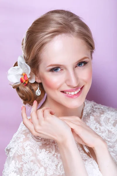 Bela noiva com penteado de casamento de moda - no fundo rosada.Retrato de close-up de noiva linda jovem. Casamento. Estúdio. — Fotografia de Stock