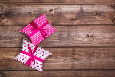 Pembe armağan ahşap masanın üstünde. Hediye kutuları