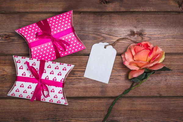 Presentes cor-de-rosa e cartão de presente na mesa de madeira. Caixas de presente — Fotografia de Stock