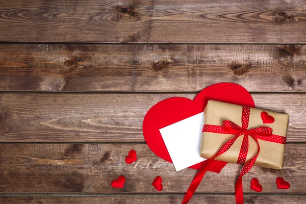 Caja de regalo vintage envuelta con lazo de cinta roja y tarjeta de regalo sobre fondo de madera — Foto de Stock