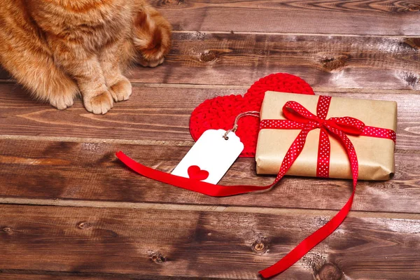 Caja de regalo vintage envuelta con lazo de cinta roja y tarjeta de regalo sobre fondo de madera — Foto de Stock