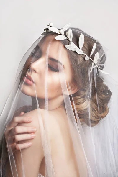 Hermosa novia con peinado de boda de moda - sobre fondo blanco.Primer plano retrato de la novia hermosa joven. Boda. Estudio shot.Beautiful retrato de novia con velo sobre su cara —  Fotos de Stock