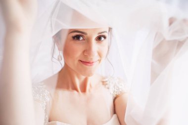 Güzel genç gelin düğün makyaj ve saç yatak ile. Güzel gelin portre onun yüzüne peçe ile. Genç güzel gelin closeup portresi. 