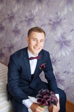 Muhteşem gülümseyen damat. gülümseyen ve gelin için bekleyen düğün smokin, ve damat. Zarif adam siyah kostüm ve papyon.