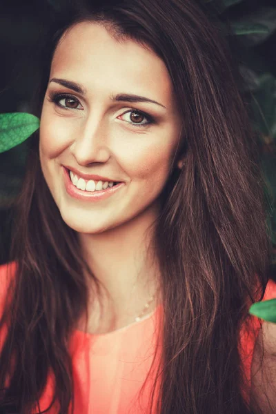 Feliz hermosa mujer joven en el parque de flores de primavera. Chica bonita con flores de primavera. Modelo de moda al aire libre — Foto de Stock