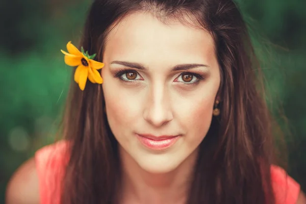 Feliz hermosa mujer joven en el parque de flores de primavera. Chica bonita con flores de primavera. Modelo de moda al aire libre — Foto de Stock