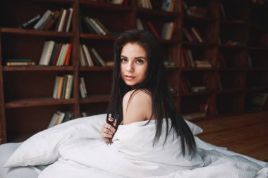 Şehvetli kadın siyah saçlı bir yatağa evde oturan