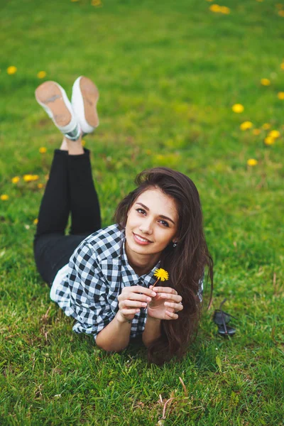 Mooie brunette vrouw houden van een bloem en glimlachen — Stockfoto