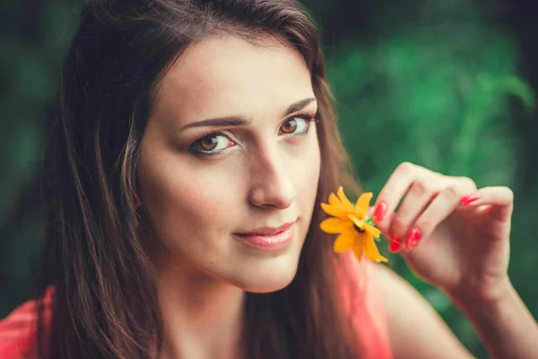 Feliz hermosa mujer joven en el parque de flores de primavera. Chica bonita con flores de primavera . — Foto de Stock