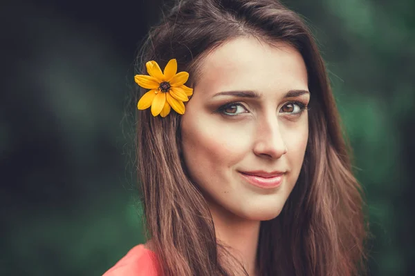 Feliz hermosa mujer joven en el parque de flores de primavera. Chica bonita con flores de primavera . — Foto de Stock