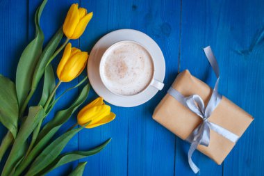 Sarı Lale ile kahve kupa çiçekler ve Günaydın mavi rustik masanın üzerine notlar