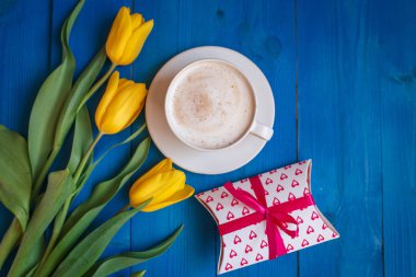 Sarı Lale ile kahve kupa çiçekler ve Günaydın mavi rustik masanın üzerine notlar 