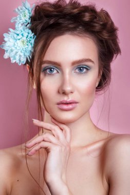 Mavi çiçek, pembe arka plan kameraya bakarak olan romantik kadın portresi. Bahar moda fotoğraf.