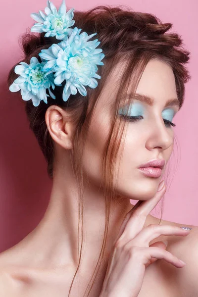 Retrato de una joven romántica con flor azul mirando a la cámara sobre fondo rosa. Primavera moda foto . — Foto de Stock