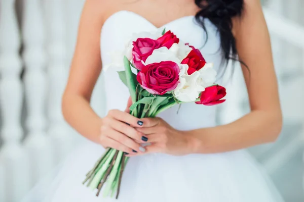 Красивый свадебный букет с красными цветами в руках невесты  . — стоковое фото