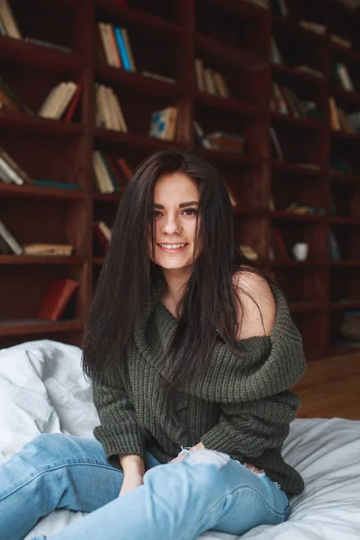 Όμορφο κορίτσι με σκούρα μαλλιά, κάθεται στο κρεβάτι το πρωί — Φωτογραφία Αρχείου