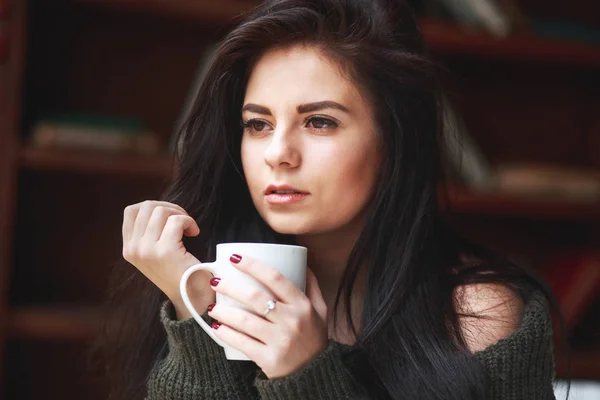 Hermosa mujer morena triste con una taza de café o té — Foto de Stock