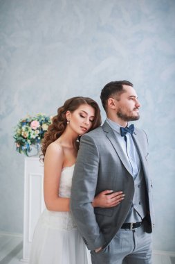 Mutlu damat ve gelin bir stüdyo güzel çiçek dekorasyonu ile poz. Sarılma Çift