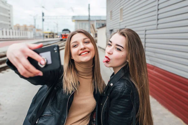 Две молодые девушки делают селфи с помощью смартфона — стоковое фото