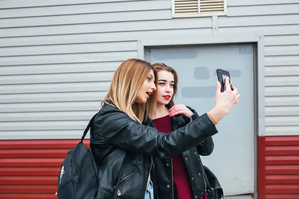 Две молодые девушки делают селфи с помощью смартфона — стоковое фото