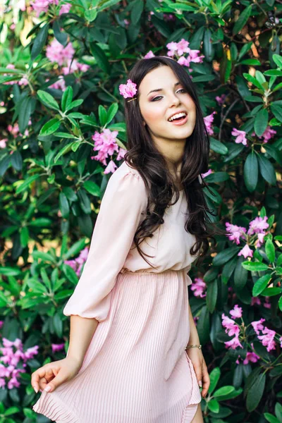 Outdoor fashion photo of beautiful young woman surrounded by flowers. Spring blossom Royalty Free Stock Photos