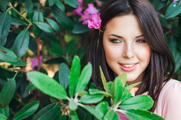 Foto de moda al aire libre de una hermosa mujer joven rodeada de flores. Flor de primavera — Foto de Stock