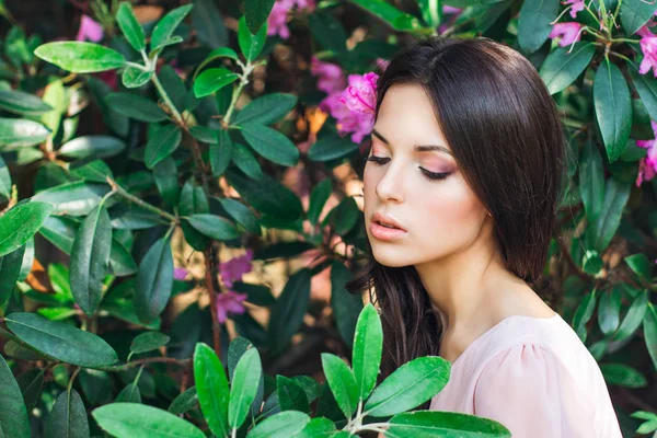 Foto de moda al aire libre de una hermosa mujer joven rodeada de flores. Flor de primavera — Foto de Stock