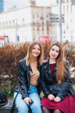İki genç kız birlikte oturan ve açık havada eğleniyor arkadaşlar. yaşam tarzı.
