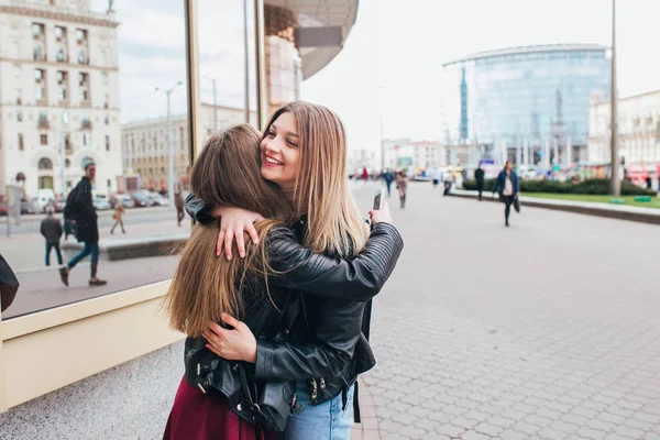 Glückliches Treffen zweier Freunde, die sich auf der Straße umarmen — Stockfoto