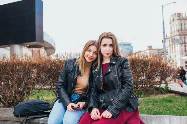 Дві дівчини друзі сидять разом і розважаються на відкритому повітрі. спосіб життя . — стокове фото