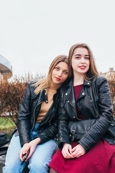Zwei junge Freundinnen, die zusammen sitzen und Spaß im Freien haben. Lebensstil. — Stockfoto