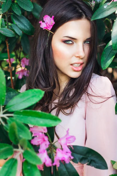 Porträtt av ung vacker kvinna poserar bland blommande träd — Stockfoto